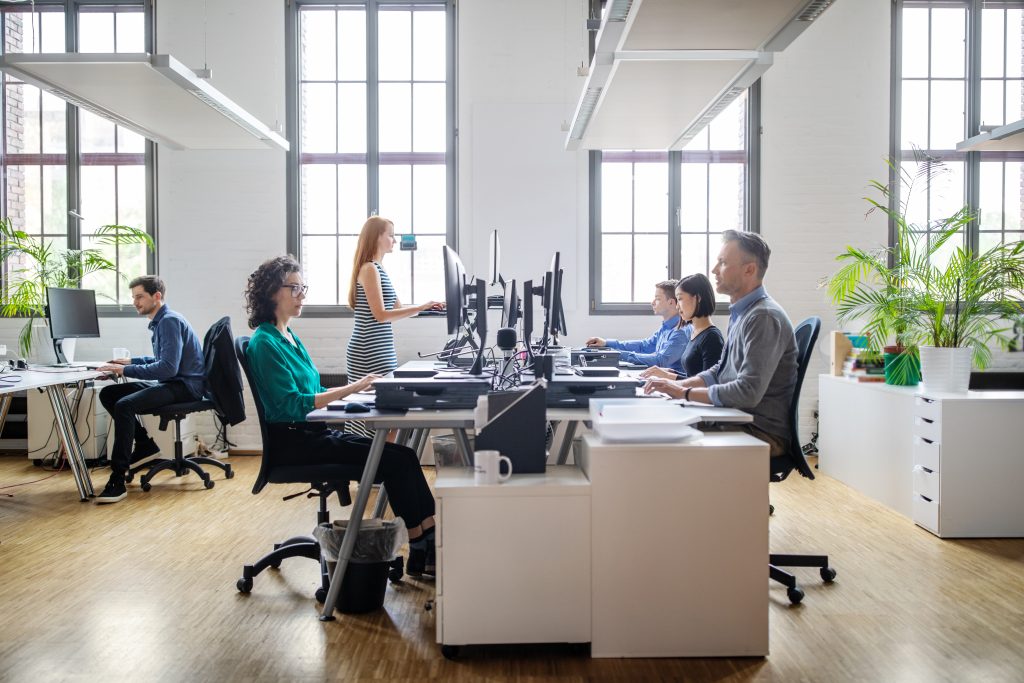 Übersetzer, die in einem Büro sitzen und am Computer arbeiten