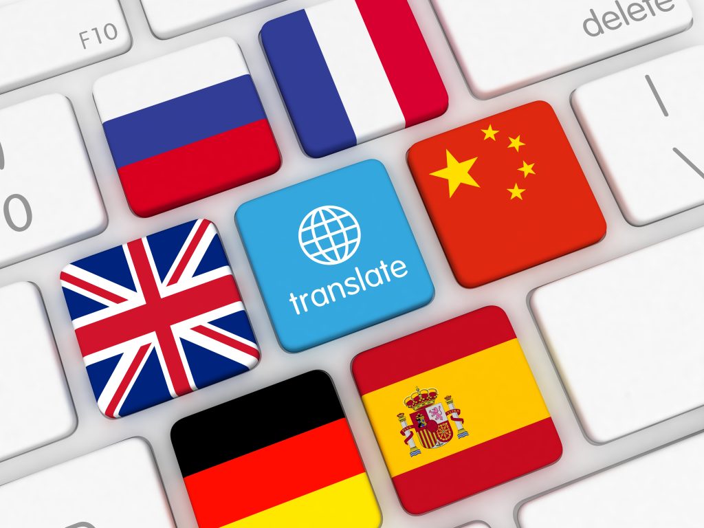 Computertaste mit der Aufschrift Übersetzen, umgeben von Bildern der spanischen, deutschen, französischen, chinesischen, russischen und britischen Flagge.